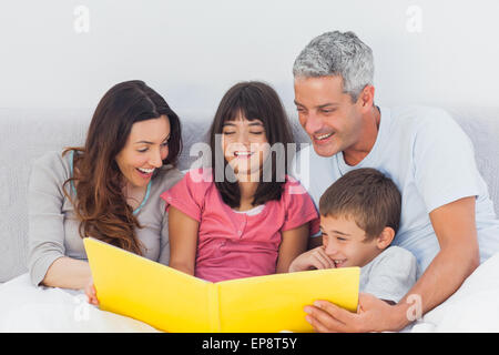 Familie betrachten gemeinsam ihr Fotoalbum im Bett Stockfoto