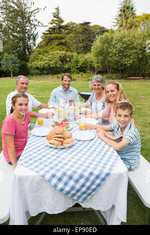 Glückliche Großfamilie beim Abendessen im Freien an Picknick-Tisch Stockfoto