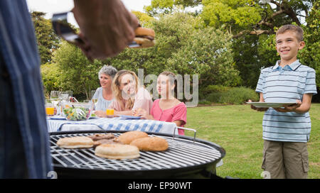 Kleiner Junge warten Grill gekocht von Vater Stockfoto