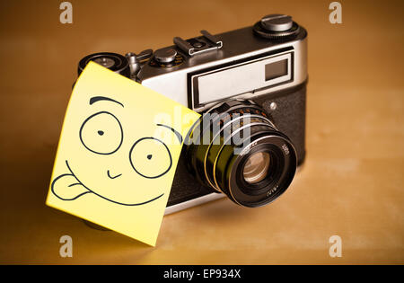 Post-It note mit Smiley-Gesicht geklebt auf einer Fotokamera Stockfoto