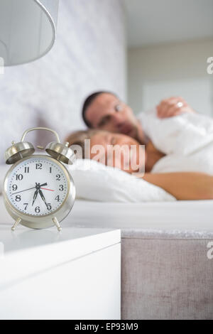 Müde paar Wecker morgens betrachten Stockfoto