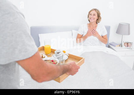 Frühstück im Bett zu bringen, erfreut Frau Mann Stockfoto