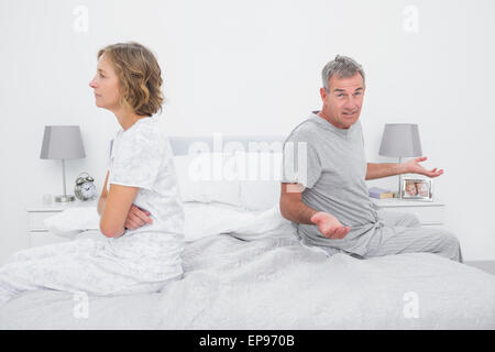 Paar, sitzen auf verschiedenen Seiten des Bettes mit einem Streit Stockfoto