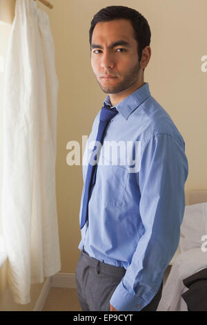 Verärgerter Mann Kamera stehend vor einem Fenster betrachten Stockfoto