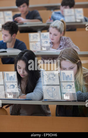 Studenten arbeiten an ihren digitalen Tablets konzentriert Stockfoto