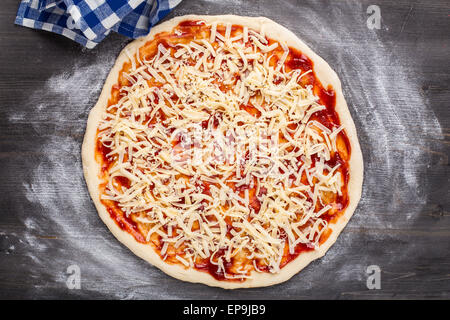 Herstellung von Pizza. Tomatensauce und Käse auf einem Teig Stockfoto