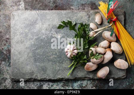 Zutaten für das kochen Spaghetti Vongole Muscheln Vongole und rohen Sapaghetti auf Stein Schiefer Hintergrund Stockfoto