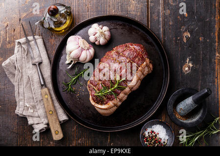 Rohe Roastbeef Rump, Gewürzen und Fleisch Gabel auf dunklem Holz Stockfoto