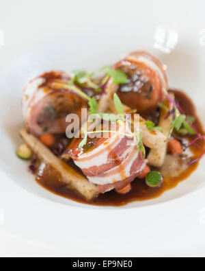 Gebackene Schweinelende von Kaninchen und Bauchspeck. Kastanie und Salbei Füllung, sauce Schalotte pürieren und Dijon-Senf. Stockfoto