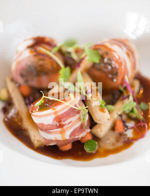 Gebackene Schweinelende von Kaninchen und Bauchspeck. Kastanie und Salbei Füllung, sauce Schalotte pürieren und Dijon-Senf. Stockfoto