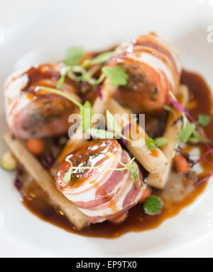 Gebackene Schweinelende von Kaninchen und Bauchspeck. Kastanie und Salbei Füllung, sauce Schalotte pürieren und Dijon-Senf. Stockfoto