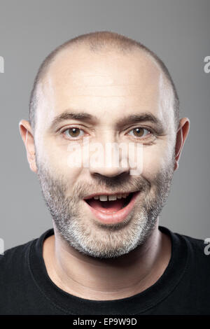 Porträt des ironisch lächelnde Menschen isoliert auf grau Stockfoto