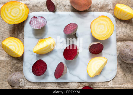 Rote Beete und goldenen rote Beete auf ein Schneidebrett Marmor. Stockfoto