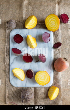 Rote Beete und goldenen rote Beete auf ein Schneidebrett Marmor. Stockfoto