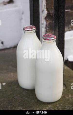 Milchflaschen vor Haustür Stockfoto