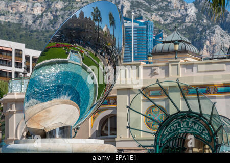 Ein Spiegelbild des Kasinos in einem Metall-Skulptur und Cafe de Paris Eingang im Hintergrund in Monte Carlo, Monaco Stockfoto