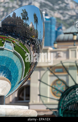 Ein Spiegelbild des Kasinos in einem Metall-Skulptur und Cafe de Paris Eingang im Hintergrund in Monte Carlo, Monaco Stockfoto