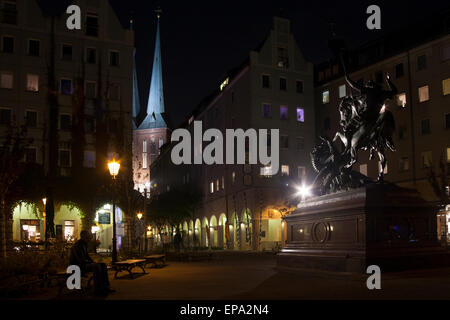 Shopping-District in Berlin bei Nacht zeigt die zwei Türme der Nikolaikirche, die älteste Kirche in Berlin, im Hintergrund. Stockfoto