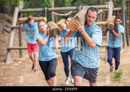 Leute, die Log-Bootcamp-Hindernis-Parcours Stockfoto
