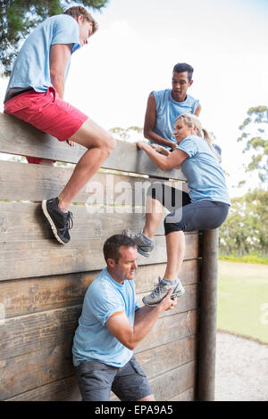 hilft Frau Wand-Bootcamp-Hindernis-Parcours Stockfoto