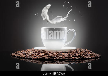 weiße Tasse mit Kaffee und Milch Spritzen auf schwarz Stockfoto