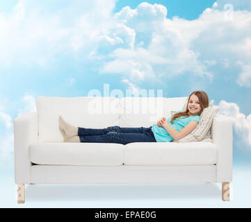 lächelnde Mädchen auf sofa Stockfoto