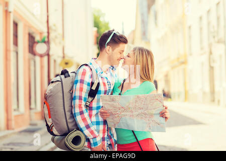 lächelnde paar mit Karte und Rucksack in Stadt Stockfoto