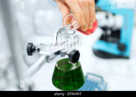 Nahaufnahme der Wissenschaftler füllen Reagenzgläser im Labor Stockfoto