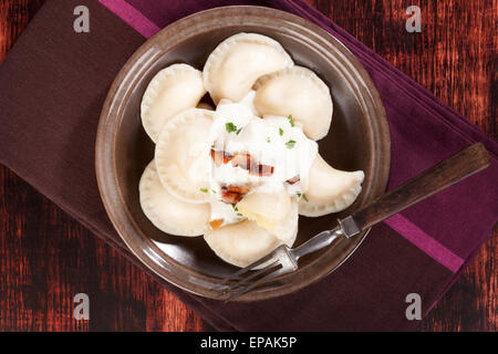 Brinsennockerl Pirohy. Knödel mit Schafen Käse Bryndza auf braune Teller auf braunem Hintergrund aus Holz. Traditionelle slowakische Küche. Stockfoto