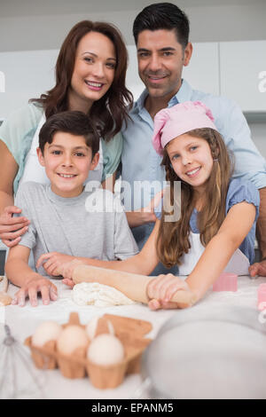 Porträt einer Familie von vier vorbereitenden Cookies in Küche Stockfoto
