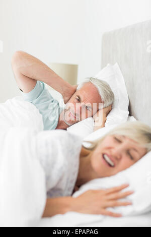 Manndeckung Ohren während die Frau schreiend im Bett Stockfoto