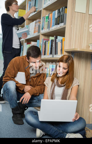 Freunde, die gemeinsam auf Laptop in der Bibliothek studieren Stockfoto
