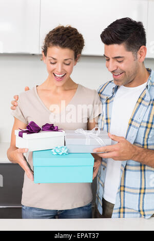 Überrascht Frau hält viele Geschenke von ihrem partner Stockfoto