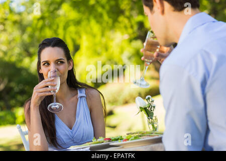 Zu zweit mit Champagner-Flöten sitzen in einem Straßencafé Stockfoto