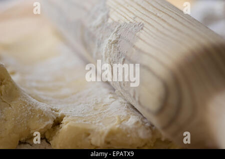 Hausgemachtes Gebäck mit einem Nudelholz ausgerollt. Stockfoto