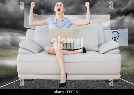 Zusammengesetztes Bild von jubelnden schöne Geschäftsfrau auf couch Stockfoto