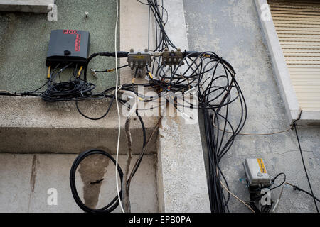Drähte und Kabel für Strom und Telefon an der Wand eines Wohnhauses in Lissabon Portugal Stockfoto