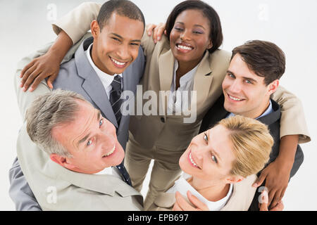 Enge wirtschaftliche Team umfassend in einem Kreis oben in die Kamera Lächeln Stockfoto