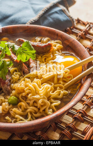 Rindfleisch-Ramen serviert asiatischen Stil. Rohes Ei kocht in dampfend heiße herzhaften Brühe Stockfoto