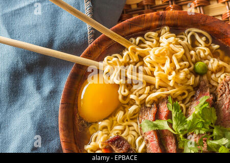 Rindfleisch-Ramen serviert asiatischen Stil. Rohes Ei kocht in dampfend heiße herzhaften Brühe Stockfoto