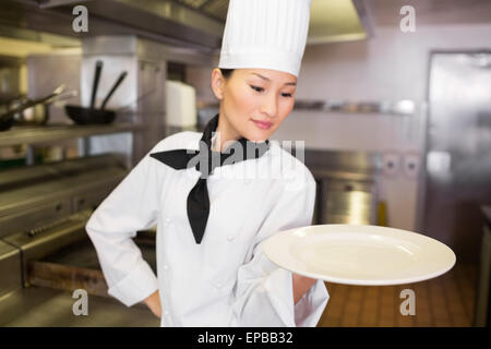 Köchin mit leeren Teller in der Küche Stockfoto