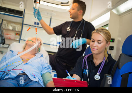 Paramedizinische Team Behandlung von Mann im Krankenwagen Stockfoto