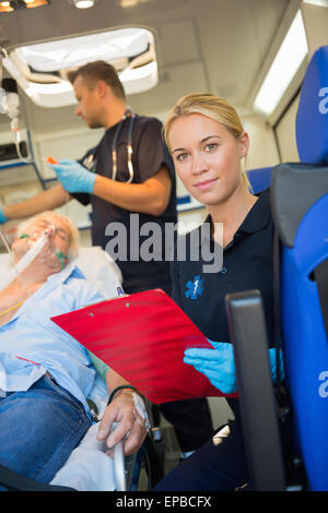 Sanitäter helfen verletzten Patienten in Ambulanz Stockfoto