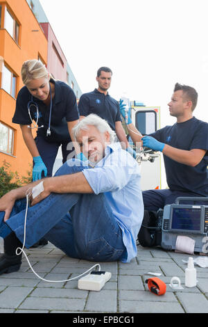 Paramedizinische Team geben ers verletzten Mann Stockfoto