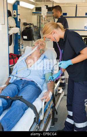 Paramedizinische Team untersuchen Patienten auf Keilrahmen Stockfoto