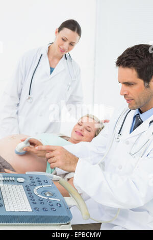 Schwangere Frau mit einer Ultraschalluntersuchung begeistert Stockfoto