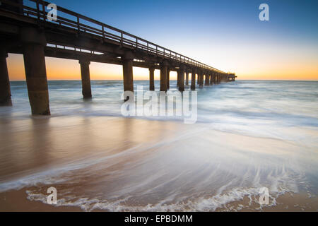 Afrika, Namibia, Swokupmond. Brücke in das Meer mit Wellen an der Küste. Stockfoto