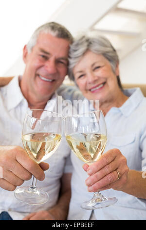 Älteres Paar auf Couch mit Weißwein Stockfoto