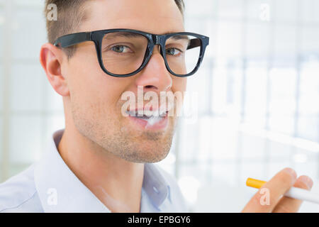 Lässige Geschäftsmann eine elektronische Zigarette rauchen Stockfoto