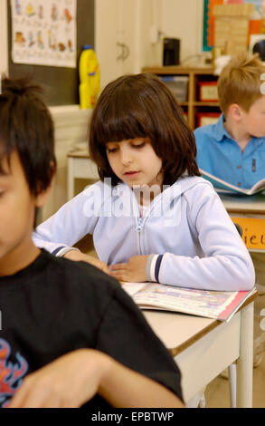 Klasse 2 Studenten arbeiten an ihren Schreibtischen in einem Klassenzimmer Stockfoto
